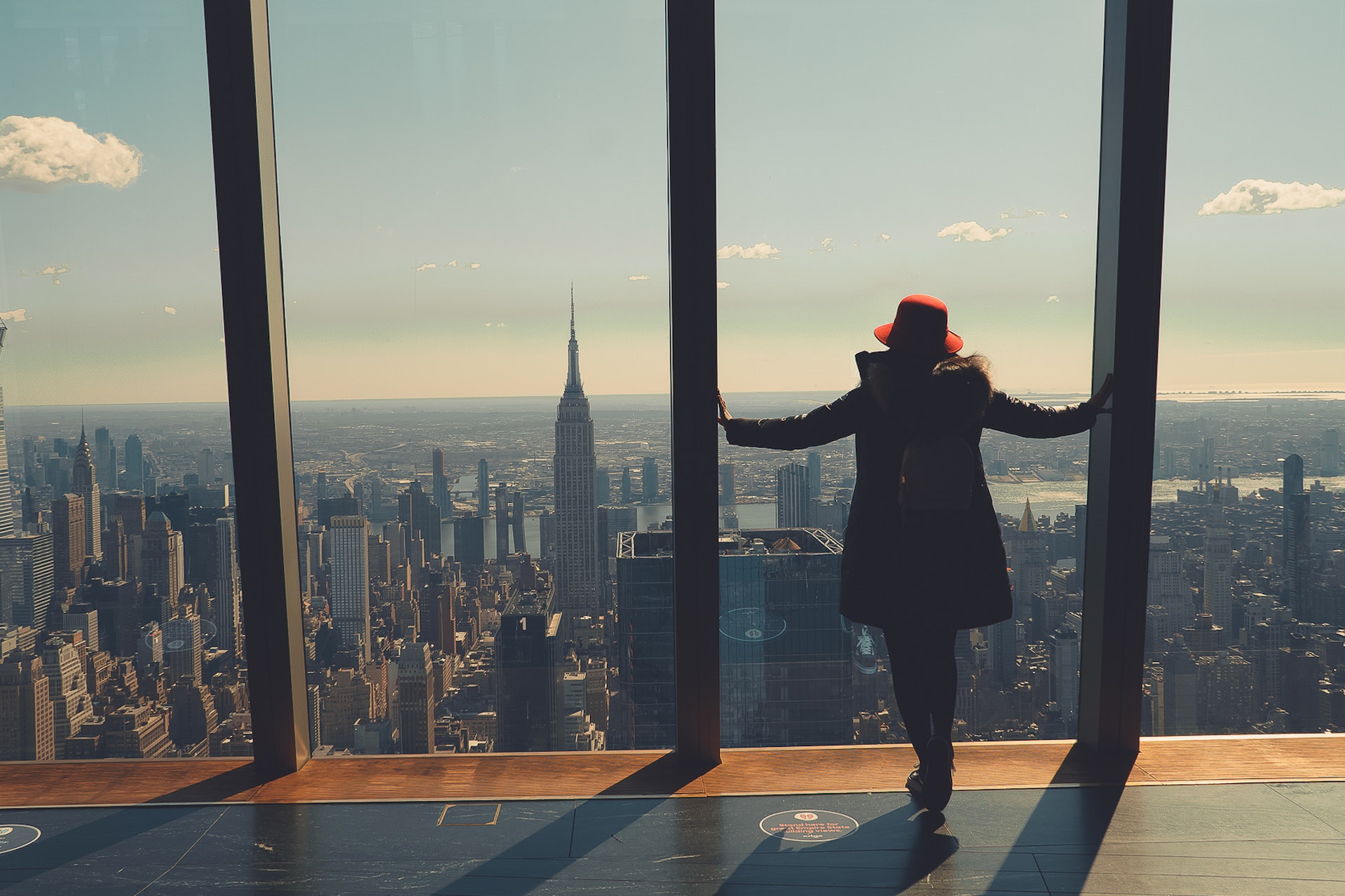 Kobieta stojąca i patrząca na piekną panoramę miasta symbolizuje, że jezyk angielski online poszerza możliwości